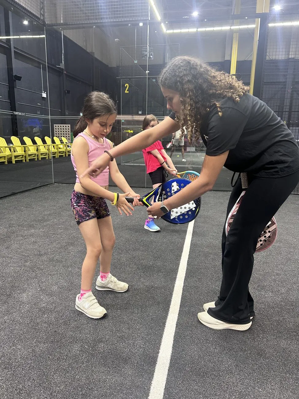 Coach teaching junior padel players