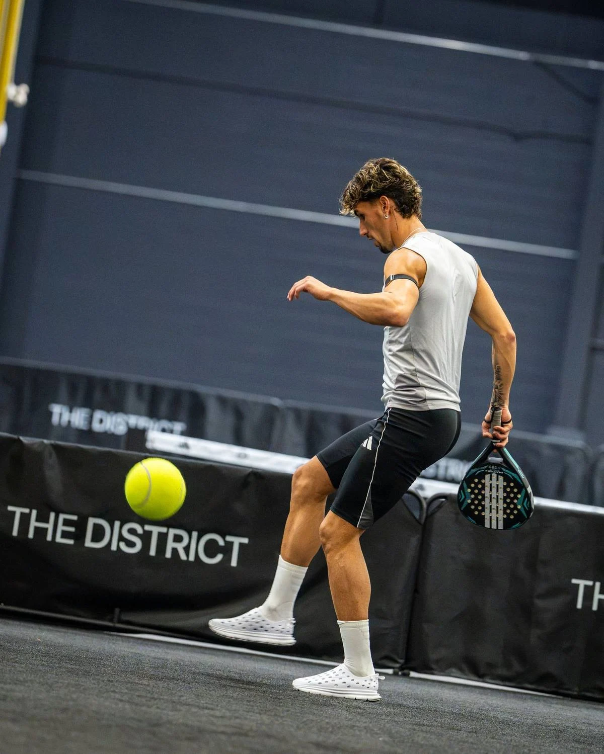 Toronto FC player juggling a ball with a padel racket on court at The District